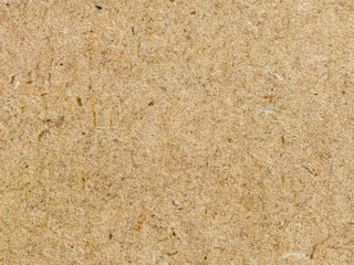 Close up textured brown recycled paper background with natural fibers