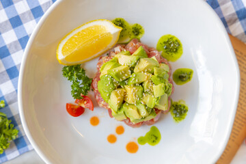 Gourmet Avocado Delight: A top-down view of an exquisitely plated culinary creation featuring a generous serving of diced avocado atop a bed of artfully arranged ingredients.