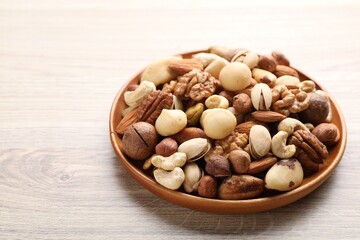 Mix of different nuts on wooden table, closeup. Space for text