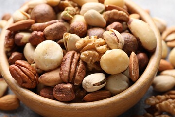 Mix of different nuts in bowl on table, closeup