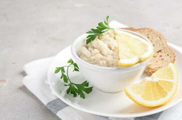 Tasty horseradish sauce with parsley and lemon slices served on light table, closeup