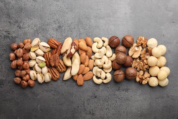 Mix of different nuts on grey table, flat lay