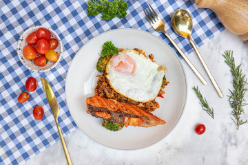 Gourmet Salmon Plate with Fried Egg: A meticulously composed photograph of a gourmet salmon dish, showcasing a perfectly cooked salmon fillet, a sunny-side-up fried egg.