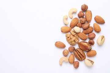 Mix of different nuts on white background, flat lay. Space for text