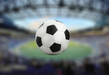 Classic black and white soccer ball floating in stadium scene
