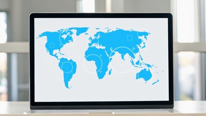 A laptop displaying a blue world map illustration with circles, set against a light background in a modern workspace.