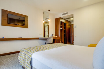 Comfortable and stylish hotel room featuring modern furnishings, a neatly made bed, and soft lighting, offering both relaxation and aesthetics for a pleasurable stay.