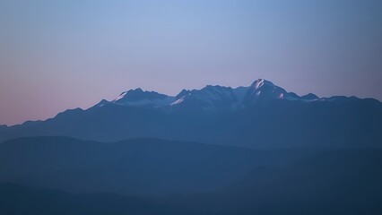 Majestic mountain range during blue hour, with a soft gradient of twilight colors.