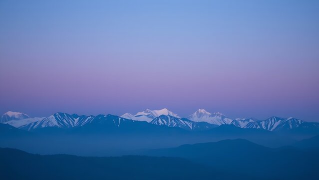 Majestic mountain range during blue hour, with a soft gradient of twilight colors.