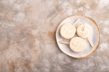 Сhocolate Ice cream in white glaze, on brown concrete, top view, flat lay, copy space