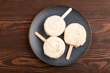 Сhocolate Ice cream in white glaze, on brown wooden, top view, flat lay, close up