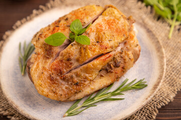 Fried Turkey Thigh with spices on plate on brown wooden, linen textile. side view, close up, selective focus