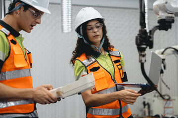 Fototapeta premium Smart Latino woman and male colleague working on AI technology in robotic electronic engineering laboratory. Hispanic engineer technician team research in robot machine futuristic automated control.