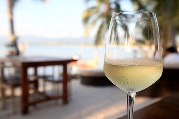 glass of cold white wine on the summer seashore by the water, relaxing by the water, a gentle background of soft color