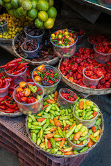 Assortment of fresh chili peppers and limes at a Brazilian street market