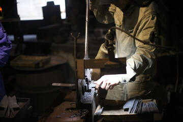 ハンドシャーで素材を包丁の形に切る職人