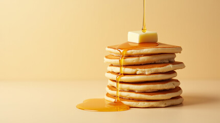 Stack of fluffy pancakes with butter on top, dripping golden maple syrup