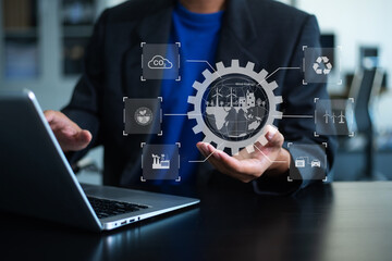 Businessman using futuristic interface with smart tech and mobile to manage ESG, clean energy, and sustainability data.