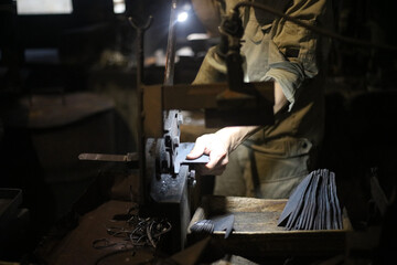 ハンドシャーで素材を包丁の形に切る職人