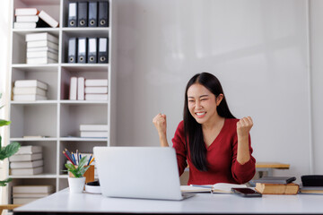 Obraz premium Excited asian freelancer celebrating success working from home office