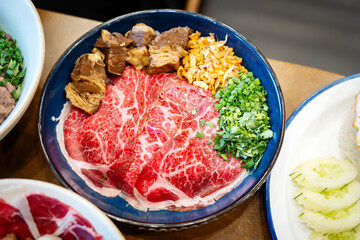 Exquisite Plate of Sliced Wagyu Beef: High-angle captures a beautifully arranged dish, featuring thinly sliced Wagyu beef, alongside a medley of fresh ingredients.