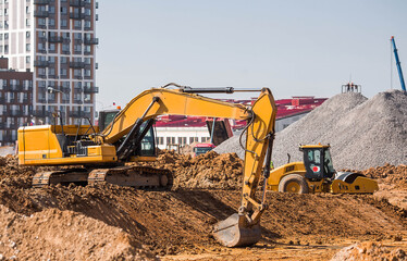 An excavator is digging the ground with a bucket for construction. Close-up of an excavator on a...