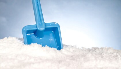 Blue plastic shovel in snow