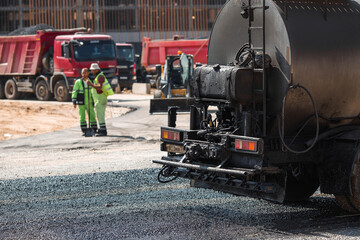 Naklejka premium Heavy equipment for earthworks and landscaping. Close-up of a tanker truck with bitumen. Preparing for asphalt laying. Road construction.