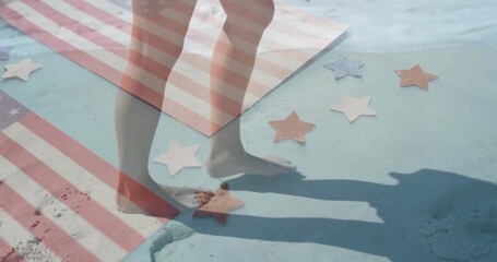 Fototapeta premium Stepping bare feet on sandy painted surface at beach edge, with striped towel, star-shaped cutouts