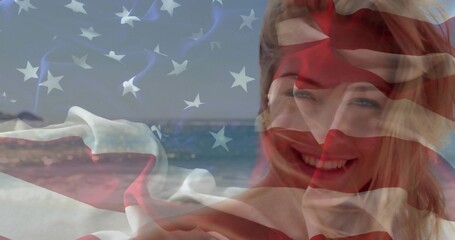 Smiling woman wearing beachwear under translucent American flag on coast with waves, copy space