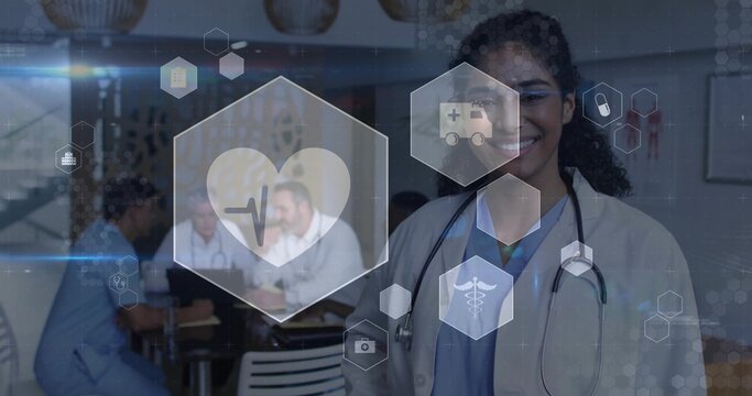 Smiling physician wearing white coat and stethoscope standing in clinic room, with medical icons