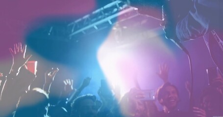 Raising hands and phones, concert fans recording live music at music hall, with spotlights and haze