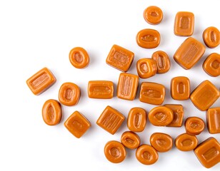 Caramel candies scattered on white background