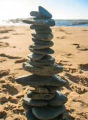 A large, uneven pile of rocks stacked on a beautiful sandy beach