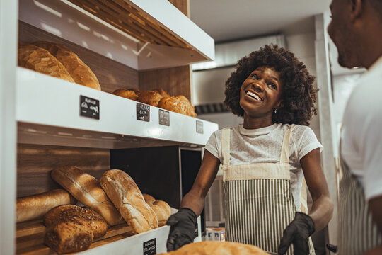 Smiling Baker Working in a Bread Shop Interacting with a Happy Customer