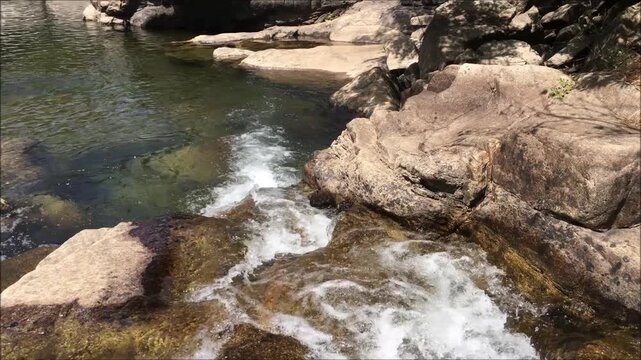 Water current of a small river ending in a small pond, clean and crystal clear water, mountain environment, Geres mountain, Portugal