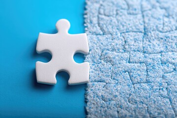 Single white puzzle piece next to a section of a blue puzzle