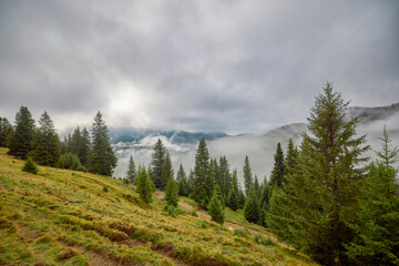 a beautiful mountain landscape in the Bucegi Mountains of Romania on a September day with clouds and fog.