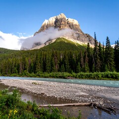 Mountain peak above a river, forest, and clouds