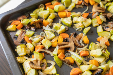 cozy fall-inspired close-up of roasted zucchini, carrots, and mushrooms on a baking tray