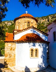 Old church with terracotta roof, white walls, and stone