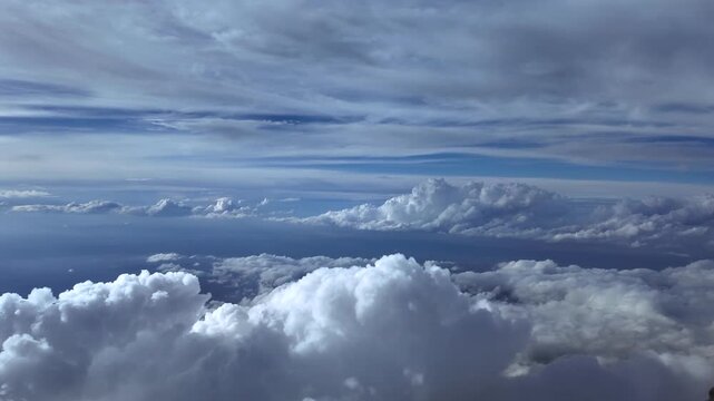 An immersive pilot&rsquo;s perspective FPV from the cockpit of a jet airplane flying above towering storm clouds, with layers of etehreal clouds above, and storm clouds in the horizon. Ultra-realistic 4K