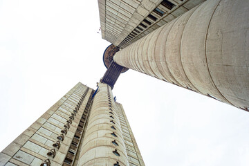 The Genex Tower in Belgrade: twin towers connected by a skybridge rise against a pale horizon. Concept of brutalist monument and futuristic vision, showcasing the geometry of 20th century architecture