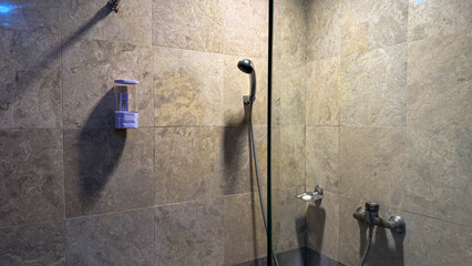 Modern Hotel Bathroom with Wall-Mounted Shower and Soap Dispenser