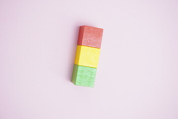 Stack of colorful wooden blocks on pink background with copy space symbolizing balance, creativity, education, and business concepts