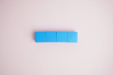 A creative arrangement of bright blue cubes aligned neatly on a soft pastel pink background