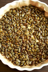 freshly baked pumpkin seeds lightly salted and arranged on a baking tray
