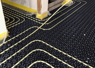 Fototapeta premium Floor heating installation in a new building, plastic pipes and pipelines. Underfloor heating system