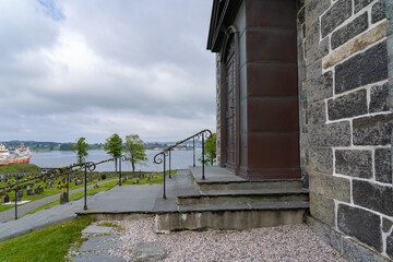 Entrance portal with cemetery in the background of the famous Norwegion Avaldsnes Church of the Island Karmoy in Norway