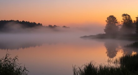 Fototapeta premium Misty Sunrise Over Calm Lake with Tree Reflections